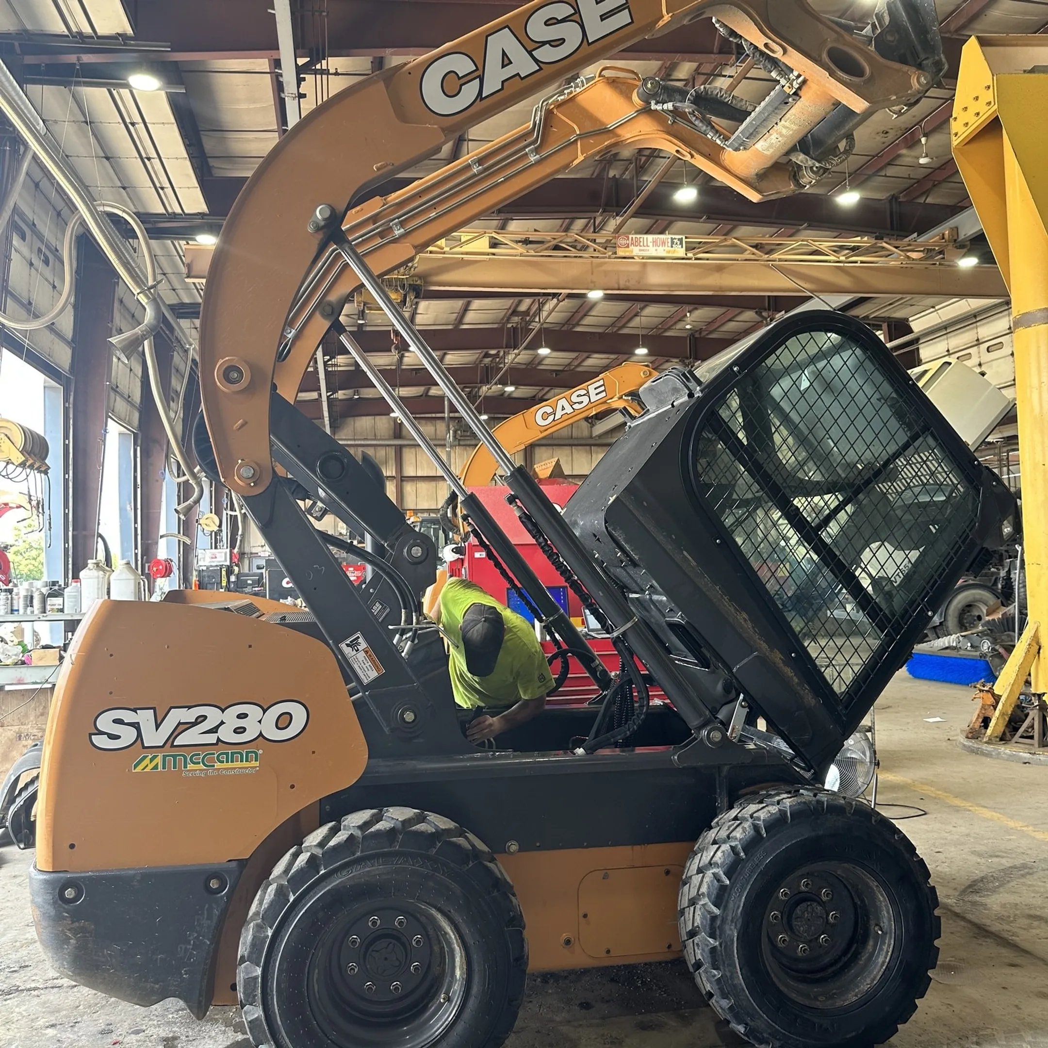 Technician diagnosing a skid steer hydraulic system