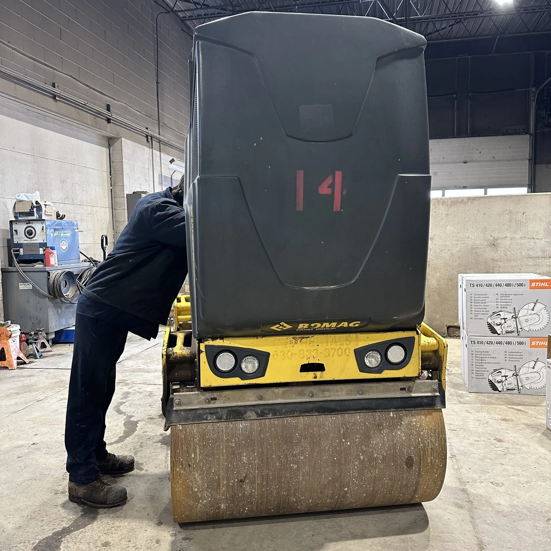 McCann technician diagnosing a plate compactor with professional service equipment