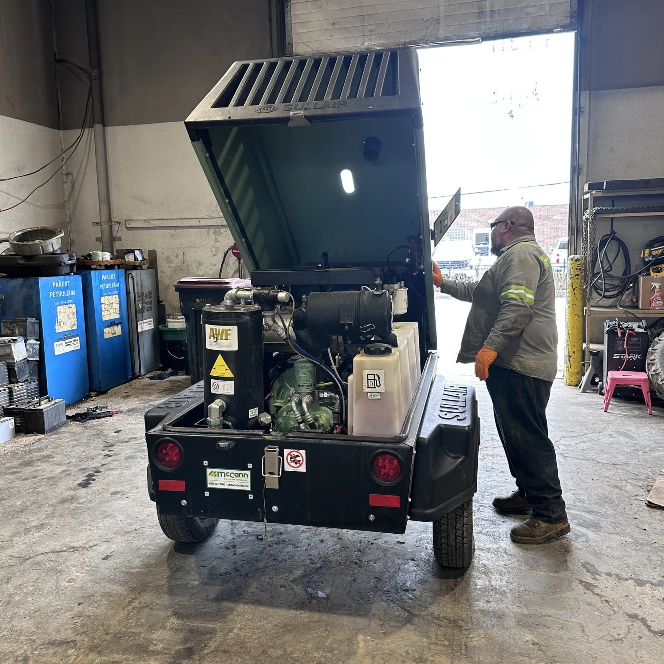 Technician performing maintenance on industrial compressor equipment