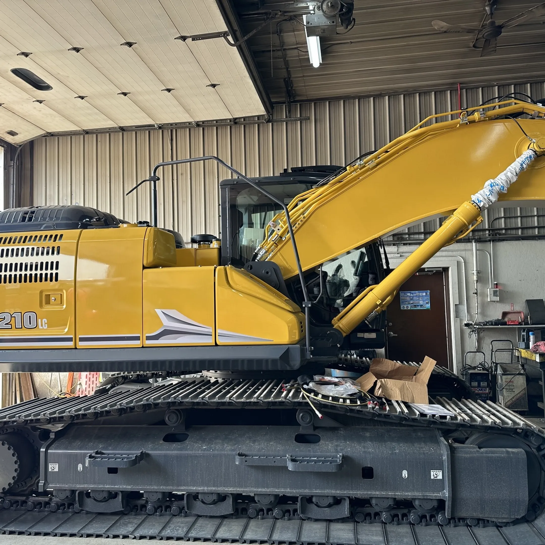 Technician diagnosing hydraulic equipment at a construction jobsite
