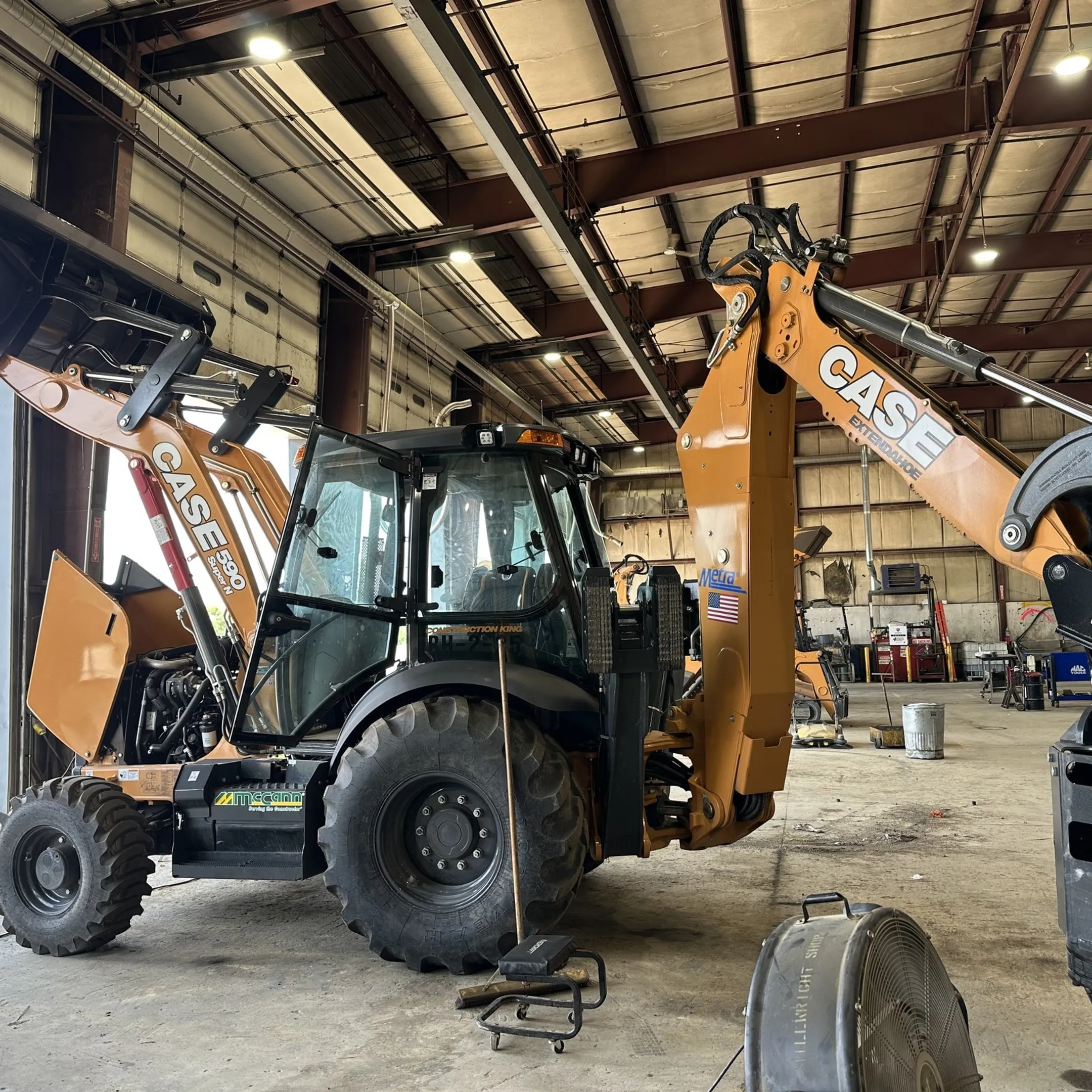 Technician repairing a hydraulic cylinder on an excavator