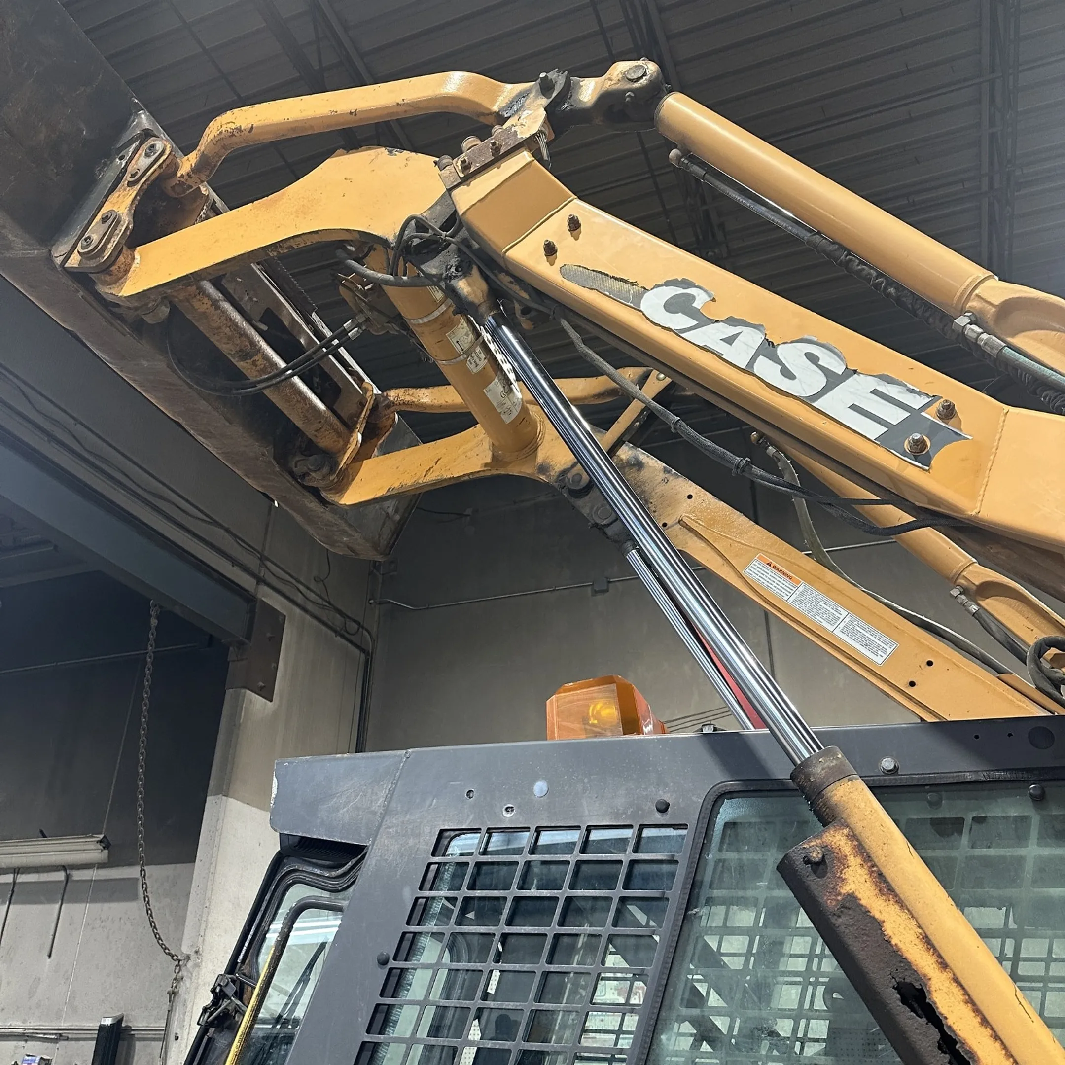Technician diagnosing hydraulic equipment at a job site