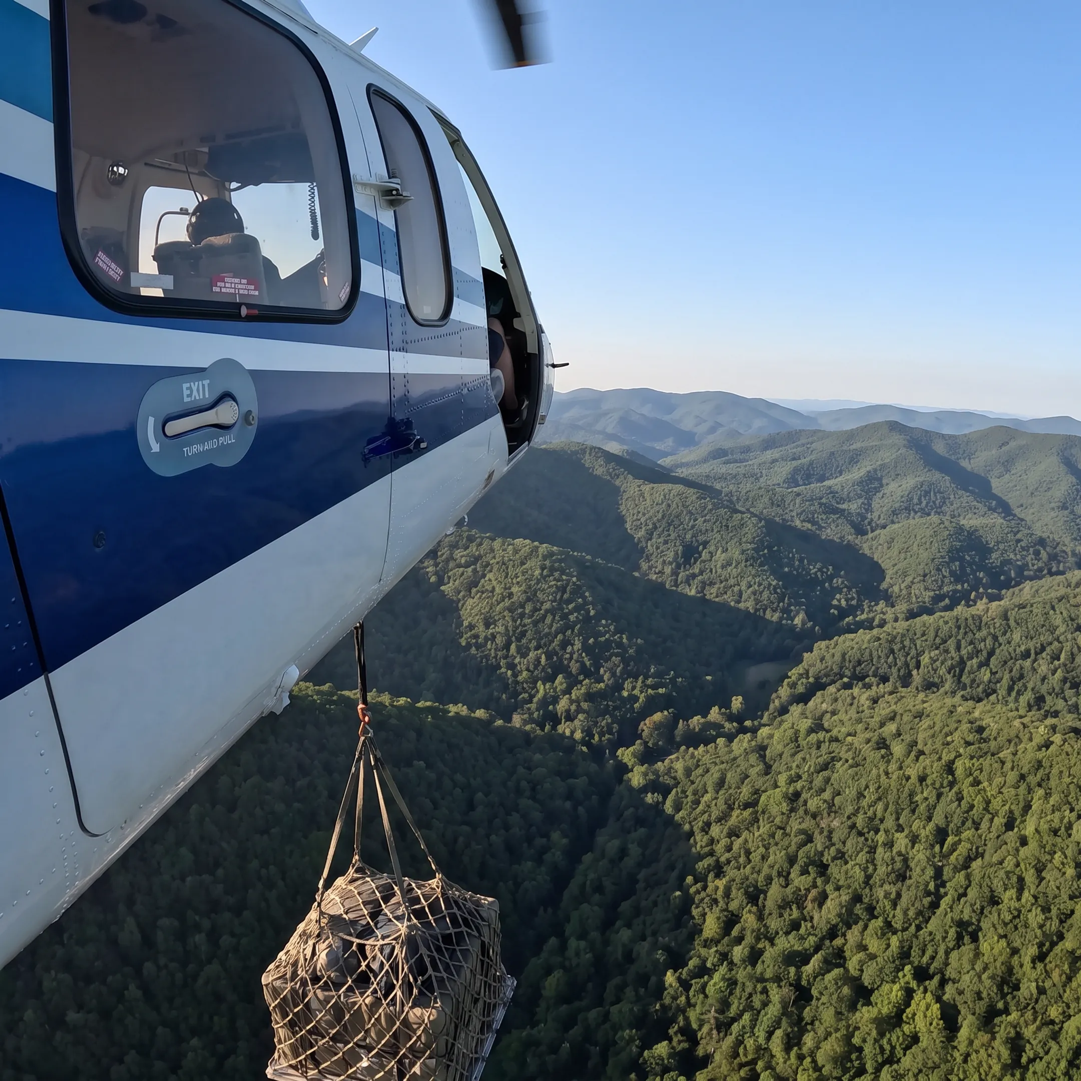 Helicopter transporting cargo over Appalachian terrain