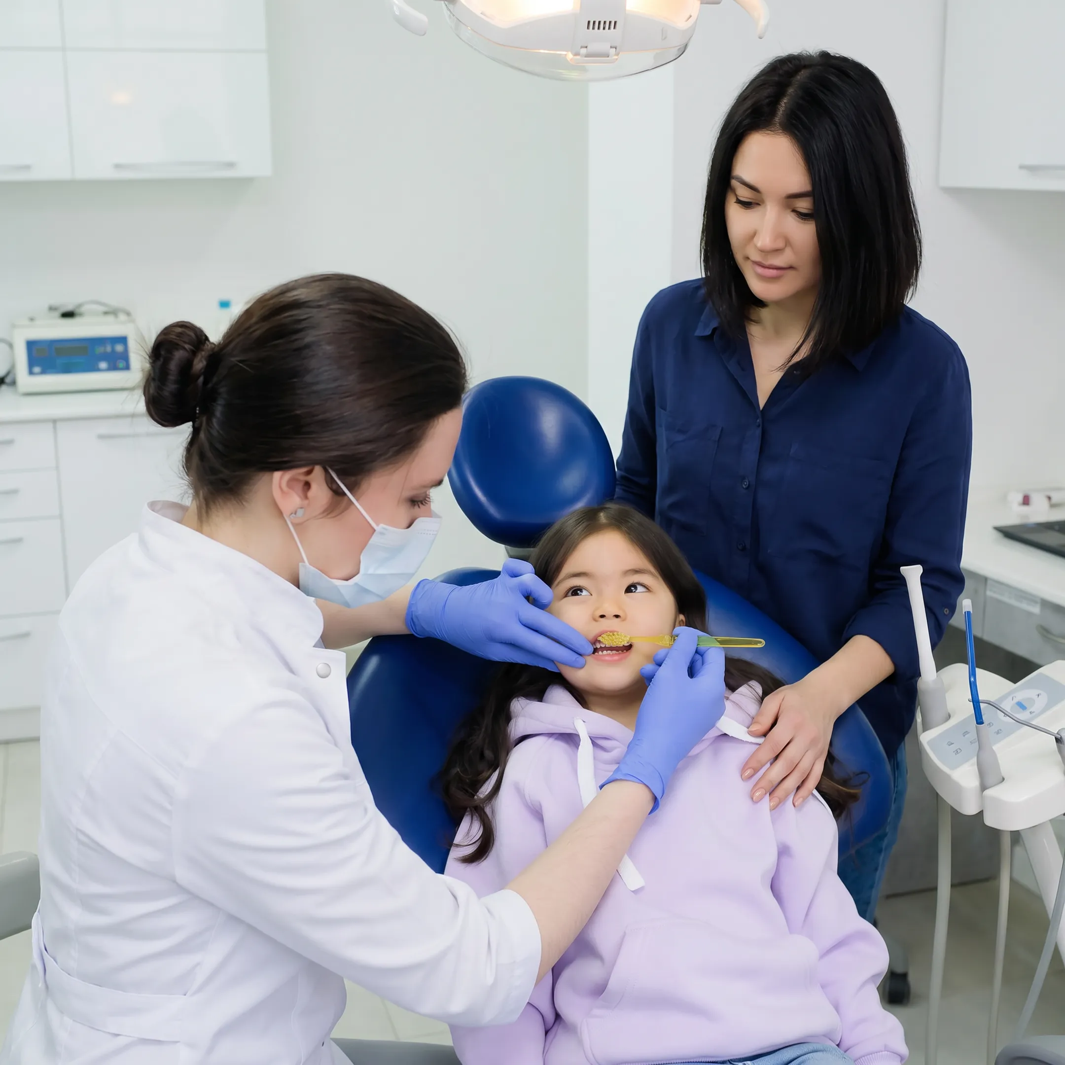 Child receiving gentle dental care with a parent nearby