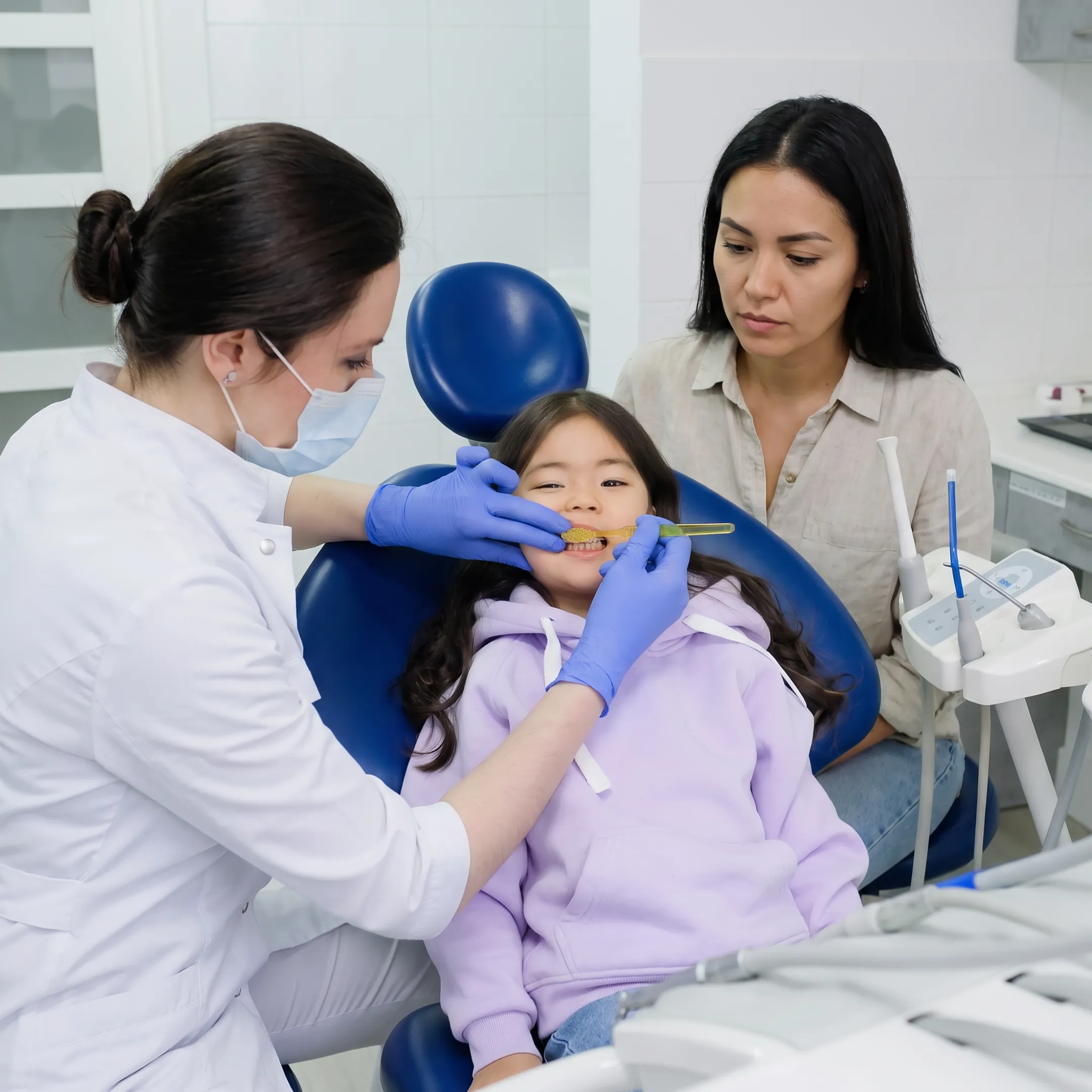 Child receiving a friendly dental examination with a parent nearby