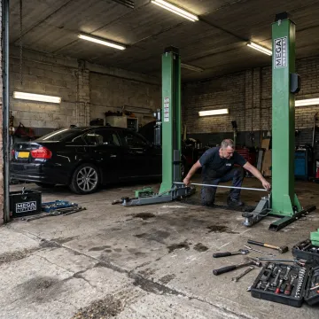 Technician planning a 2 post car lift installation
