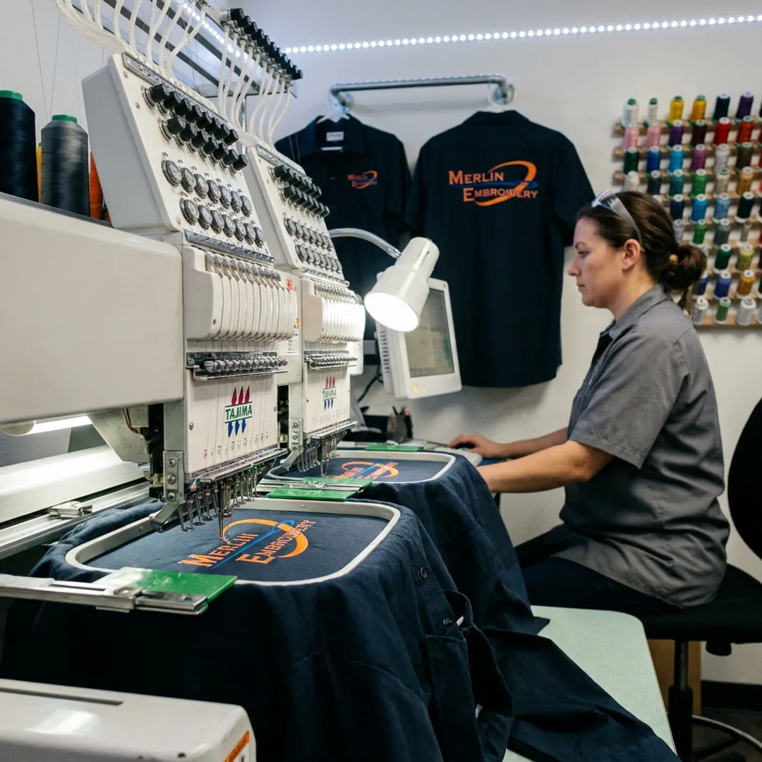 Embroidery machine stitching a mechanic shirt logo