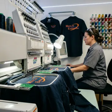 Embroidery machine stitching a mechanic shirt logo
