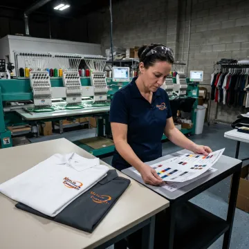Technician preparing embroidered corporate uniforms