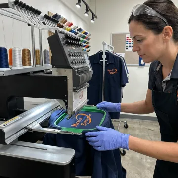 Embroidery machine stitching a logo on a work shirt