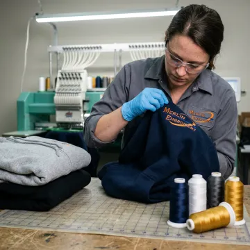 Embroidered workwear hoodies being inspected