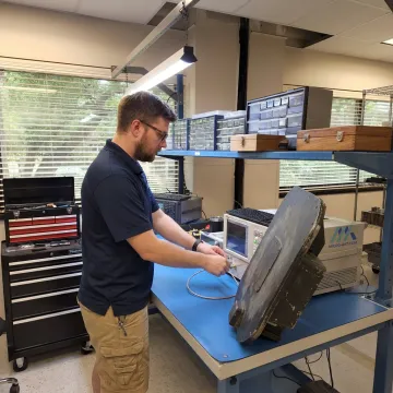 Engineer testing a SATCOM antenna in an RF lab