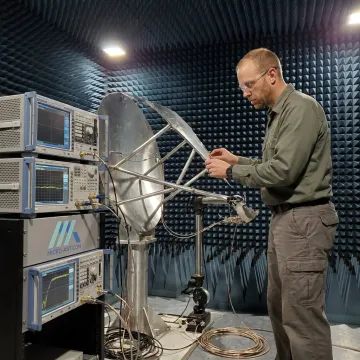 Engineer testing a satellite antenna prototype