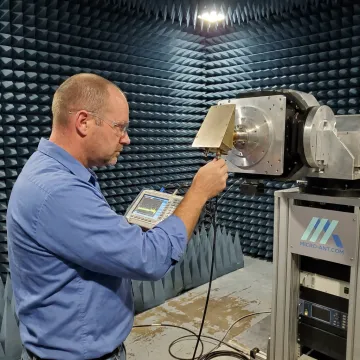 Engineer testing aircraft SATCOM antenna in RF chamber