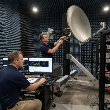 Engineers inspecting a high gain SATCOM antenna assembly