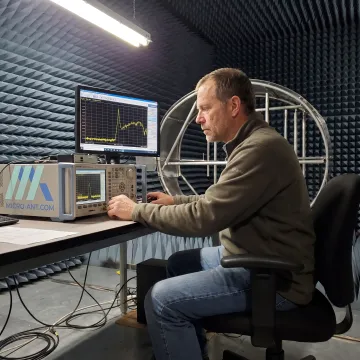 Engineer conducting antenna measurements in an RF test chamber