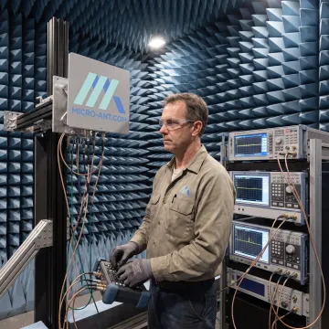 Engineer testing a satellite antenna in a near-field chamber