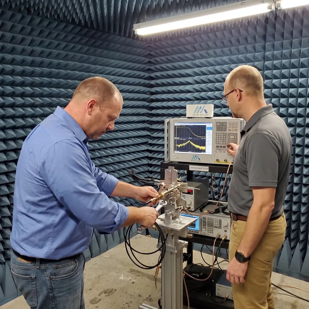 Engineers integrating RF antenna components in a test chamber