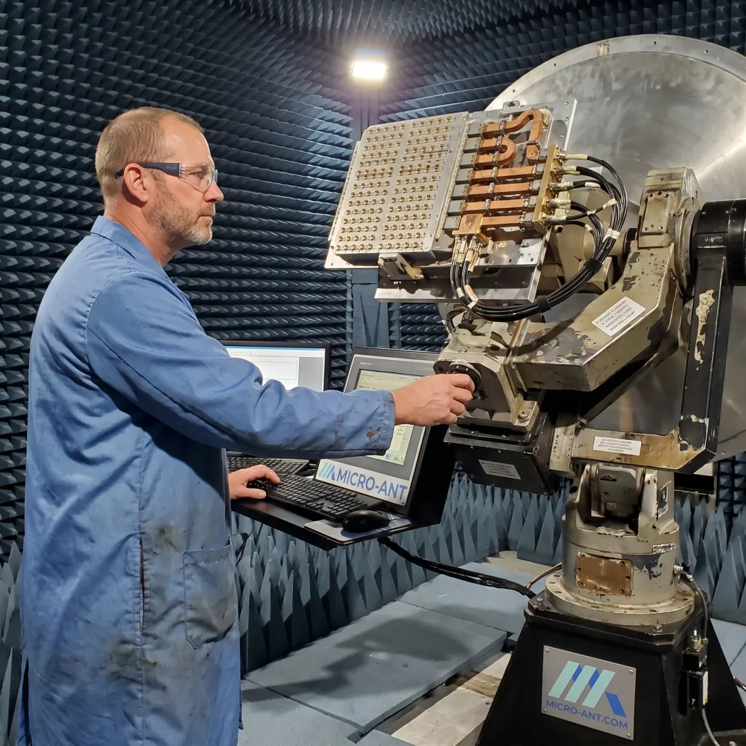 Technician testing an antenna in a near-field measurement chamber