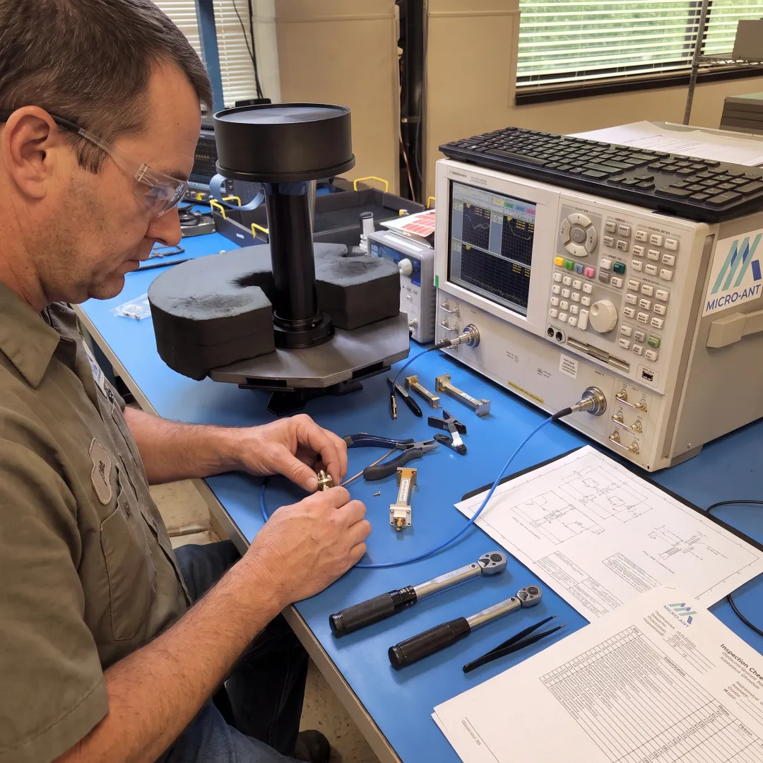 Technician assembling precision RF antenna hardware