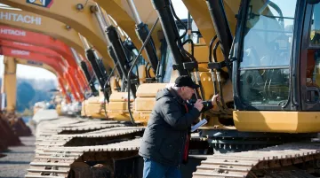 Heavy equipment pre-auction inspection checklist mechanic examining excavator engine hours