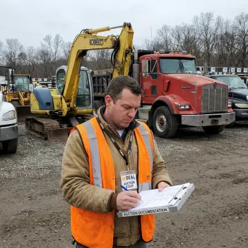 Auction team documenting heavy equipment for sale