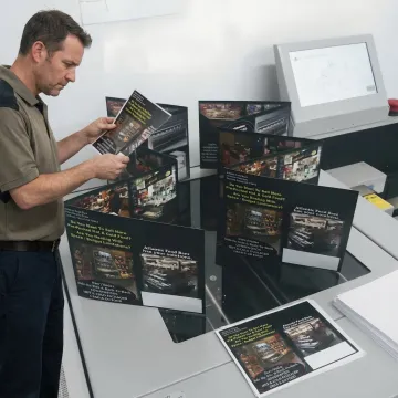 Printer operator reviewing flyer proofs