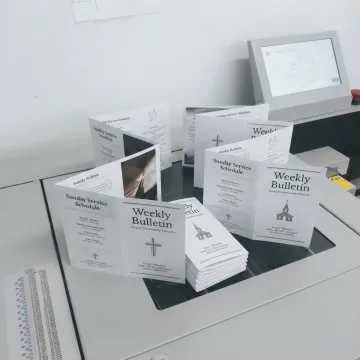 Freshly printed church bulletins on a print shop table