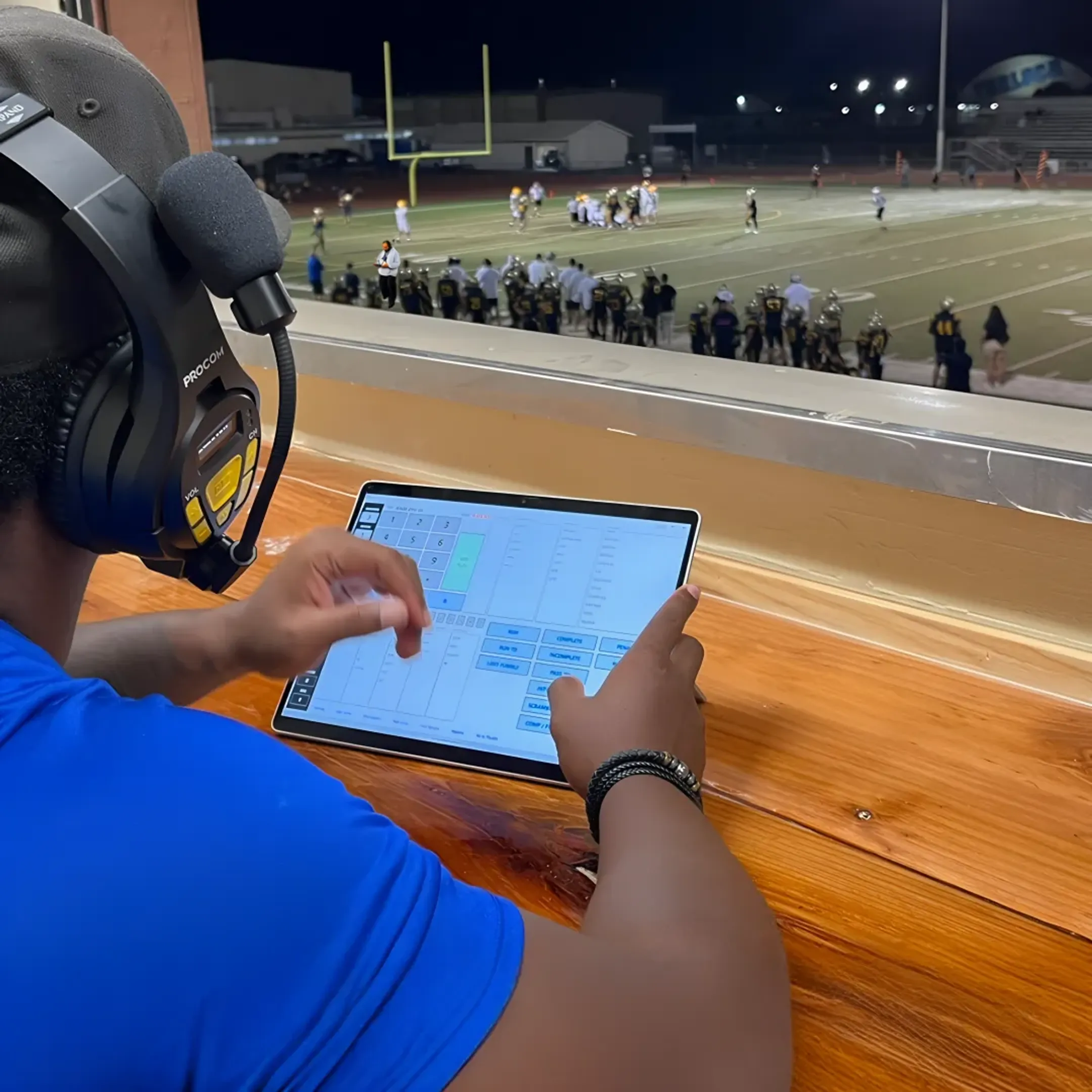 Coach reviewing automated football stat reports on tablet
