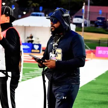 Coach reviewing football play-by-play analytics on a tablet