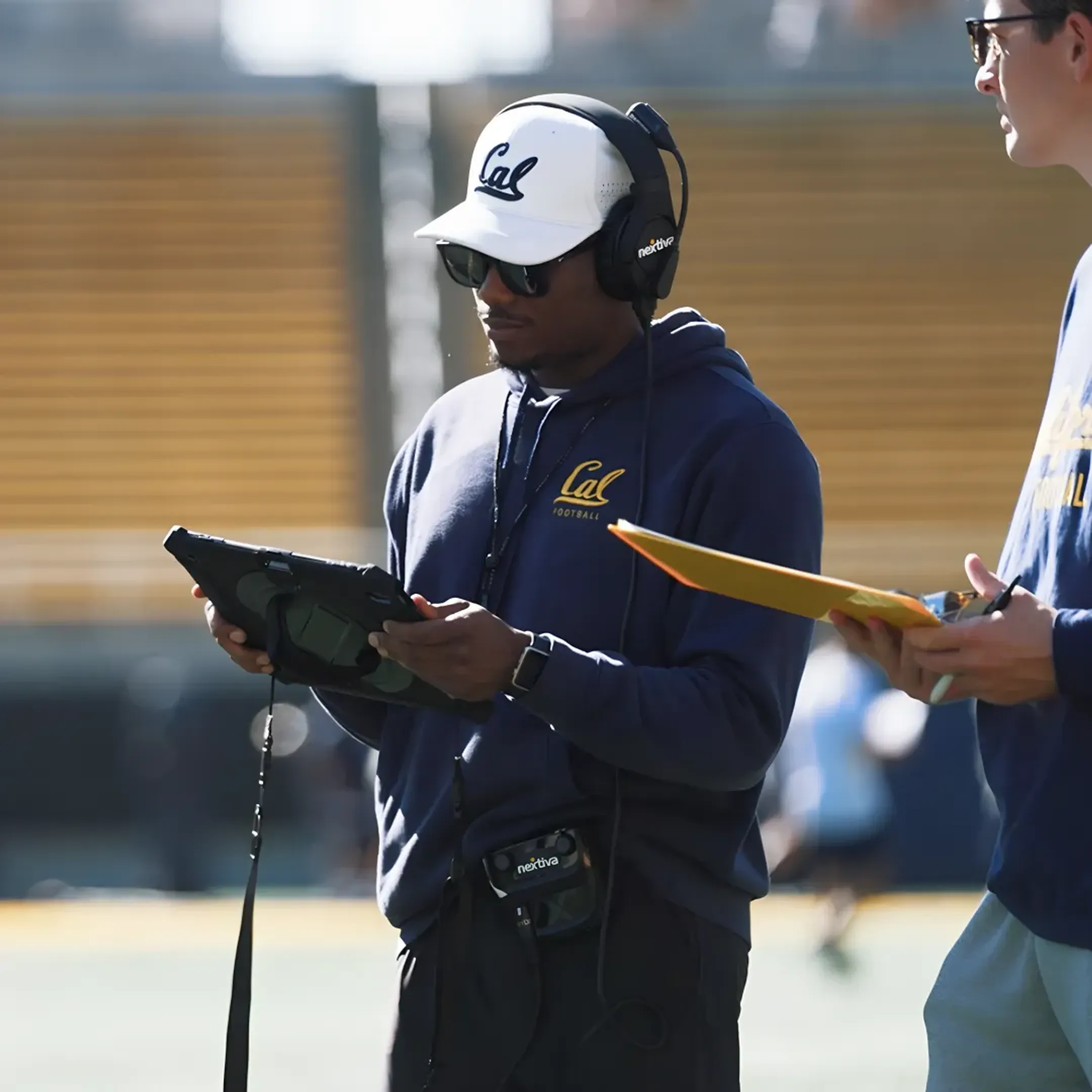 Football coach analyzing play-by-play data on a tablet