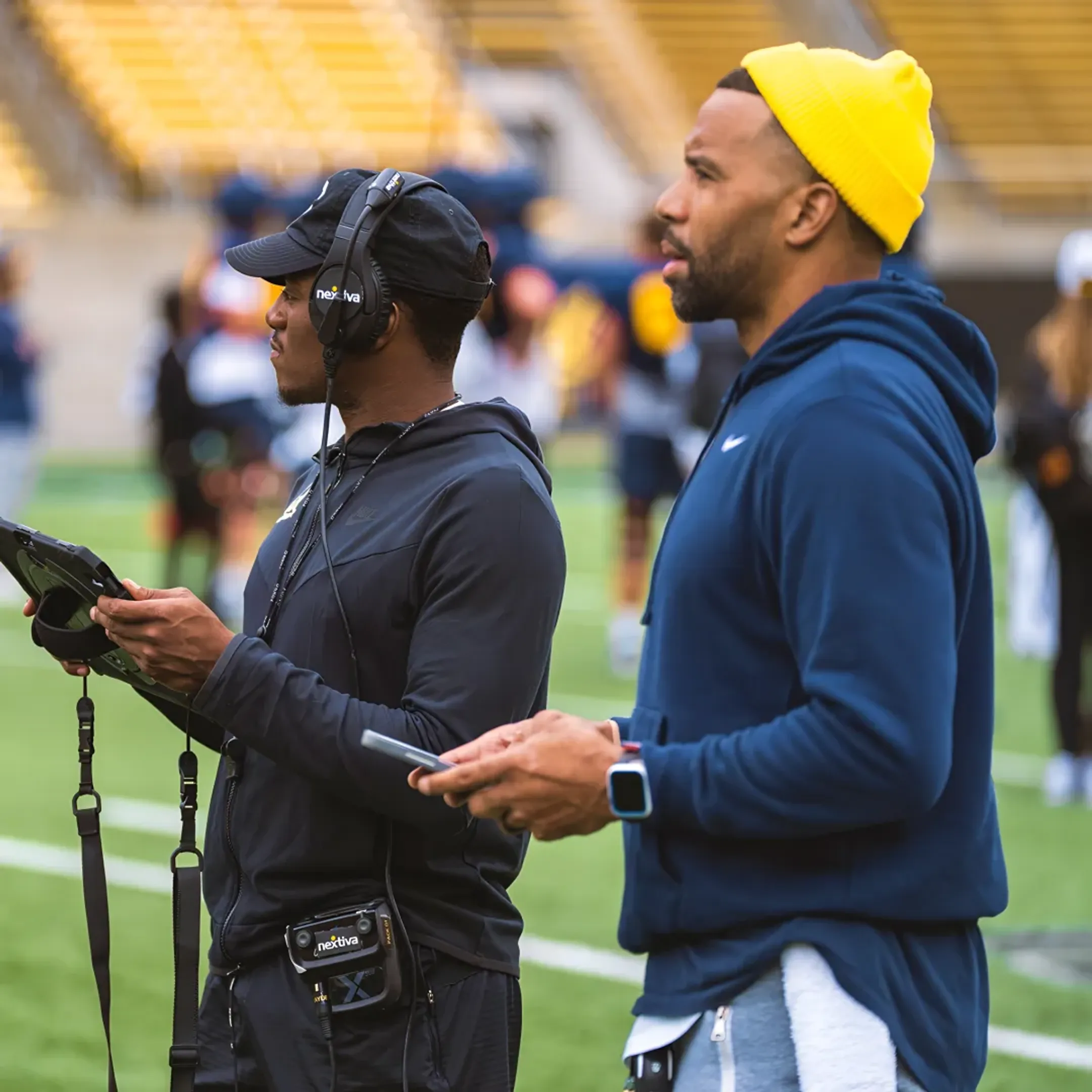 Football staff reviewing live analytics reports on tablets