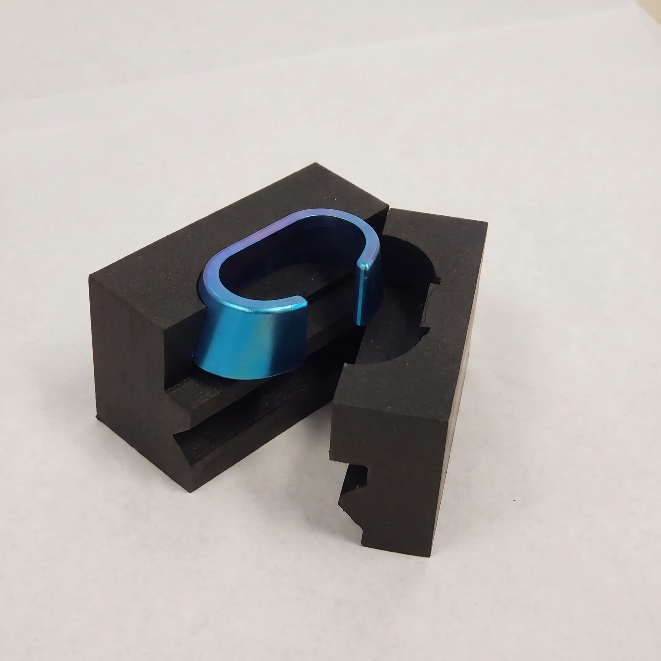 Clavicle hook plate prototype beside inspection equipment and precision machining tools