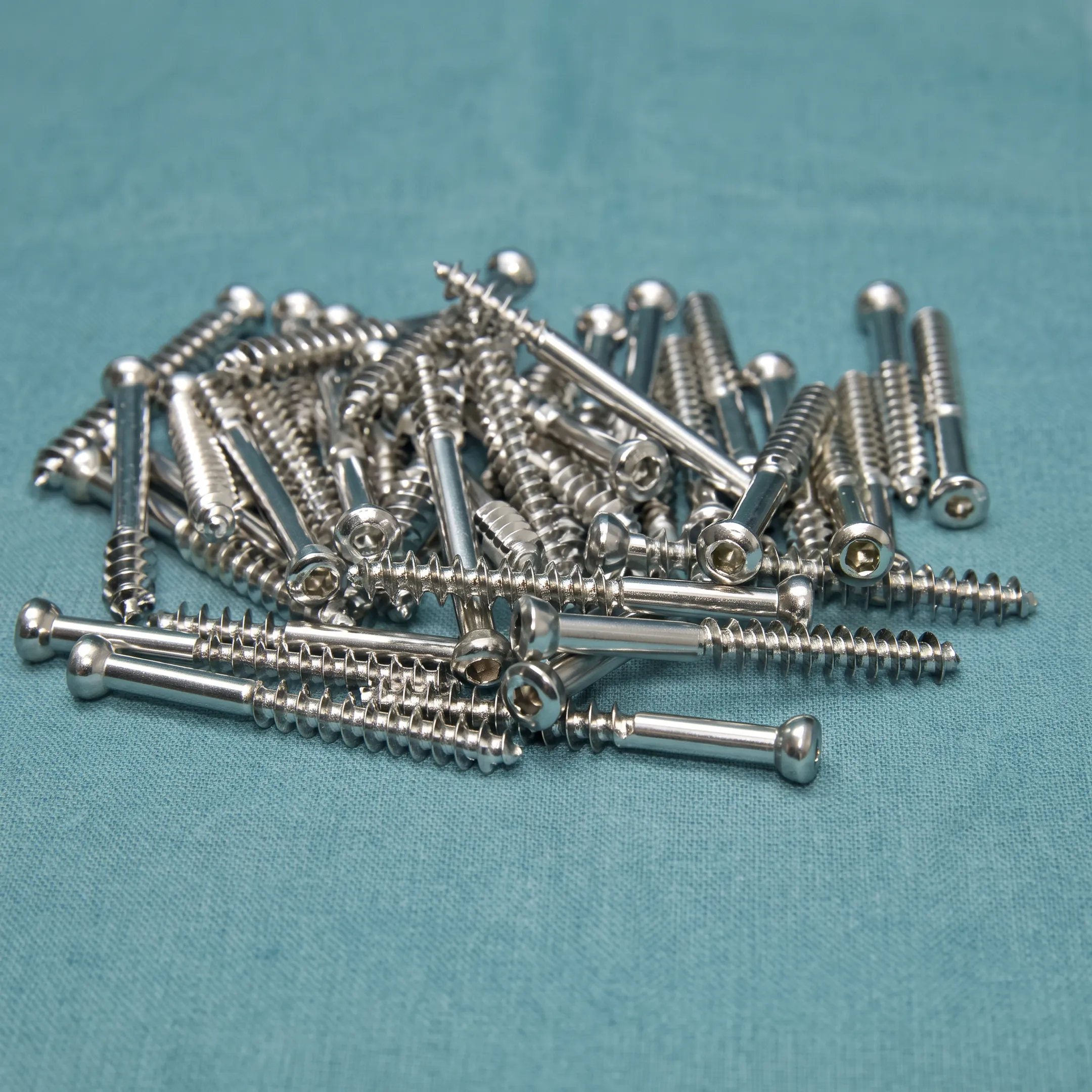 Engineer reviewing precision cannulated screw components and technical drawings