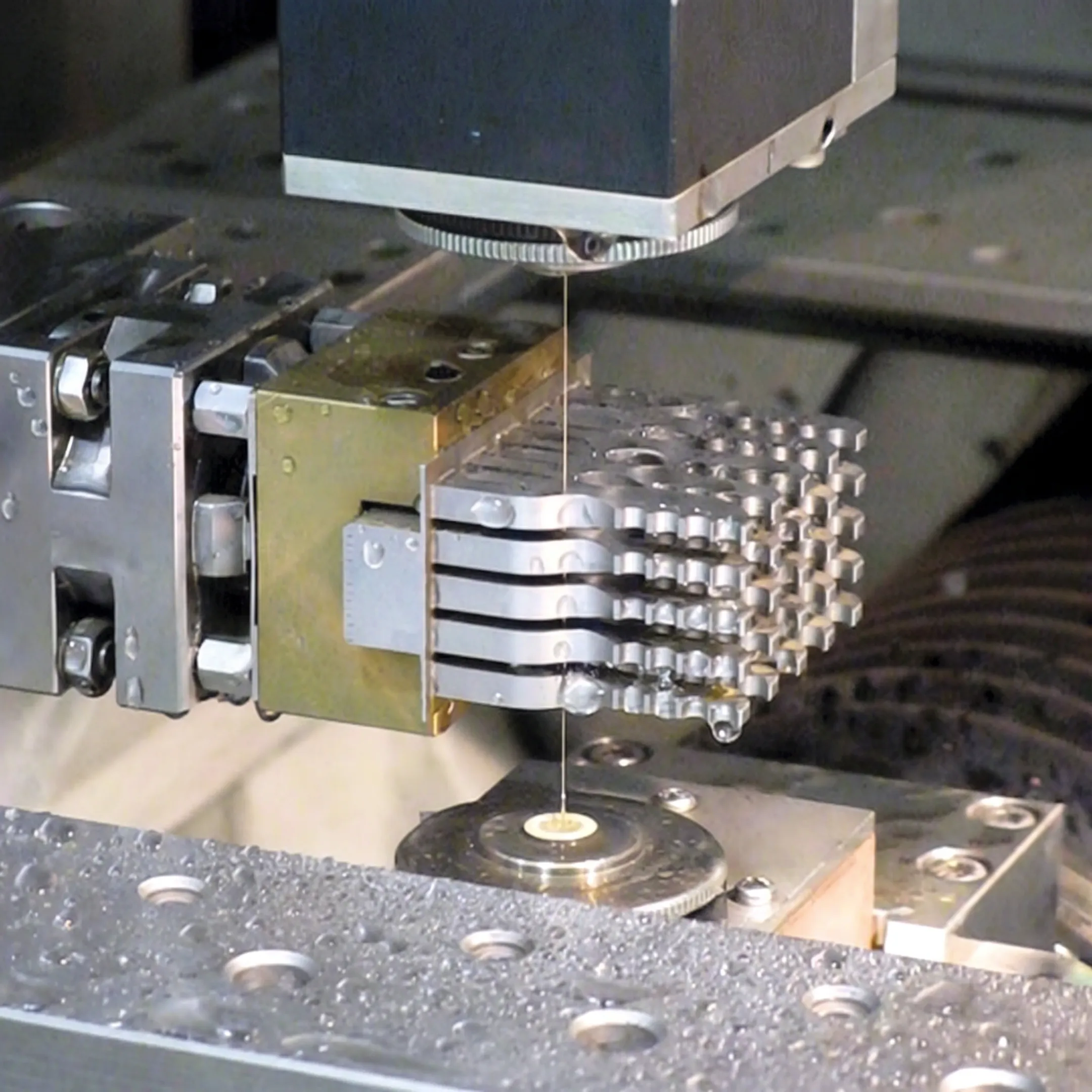 Technician monitoring wire EDM production of an orthopedic component