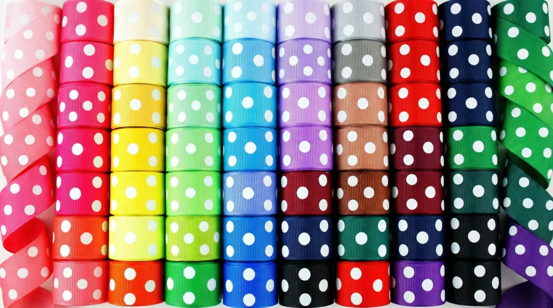 Colorful printed grosgrain hairbow ribbons with polka dot and patterned designs on spools