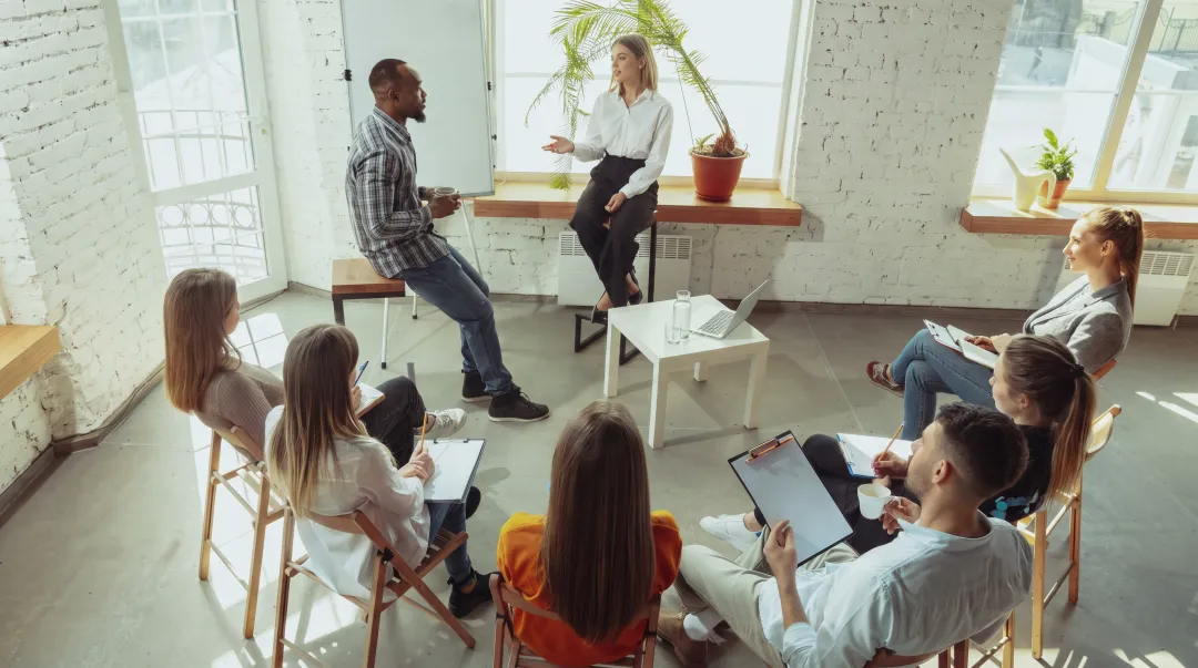Modern corporate training session with diverse employees engaged in leadership development workshop