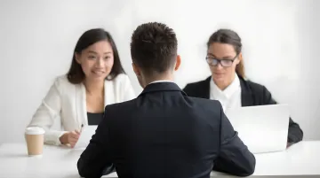 Employee training session with mentor teaching technical skills to team member in workplace