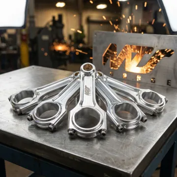 Forged aluminum connecting rods with precision-machined surfaces on a workshop bench