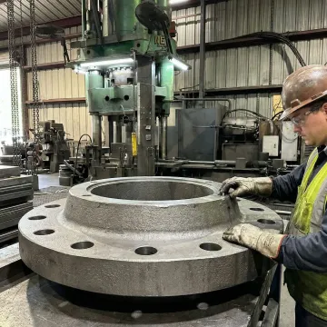 MTS Forge technician inspecting carbon steel forged flange at Coatesville PA manufacturing facility