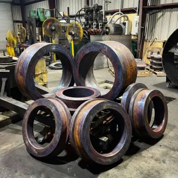 Forged steel rings of multiple sizes stacked in an industrial forge facility