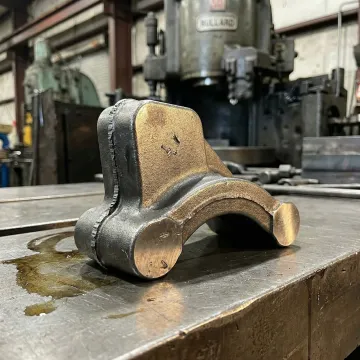 Close-up of a closed-die forged metal component fresh from the press in a forging facility