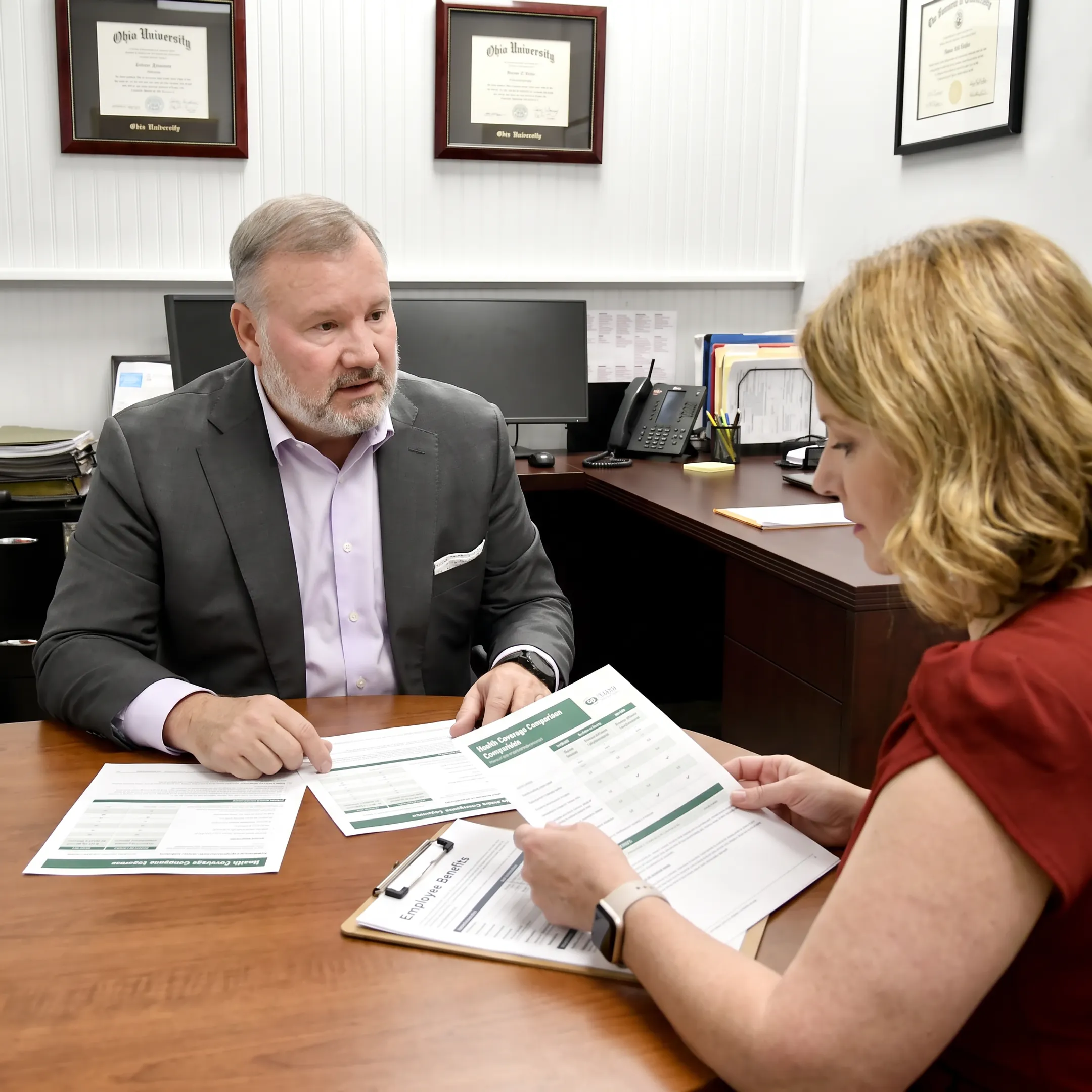 Adviser reviewing employee benefits options with business owner