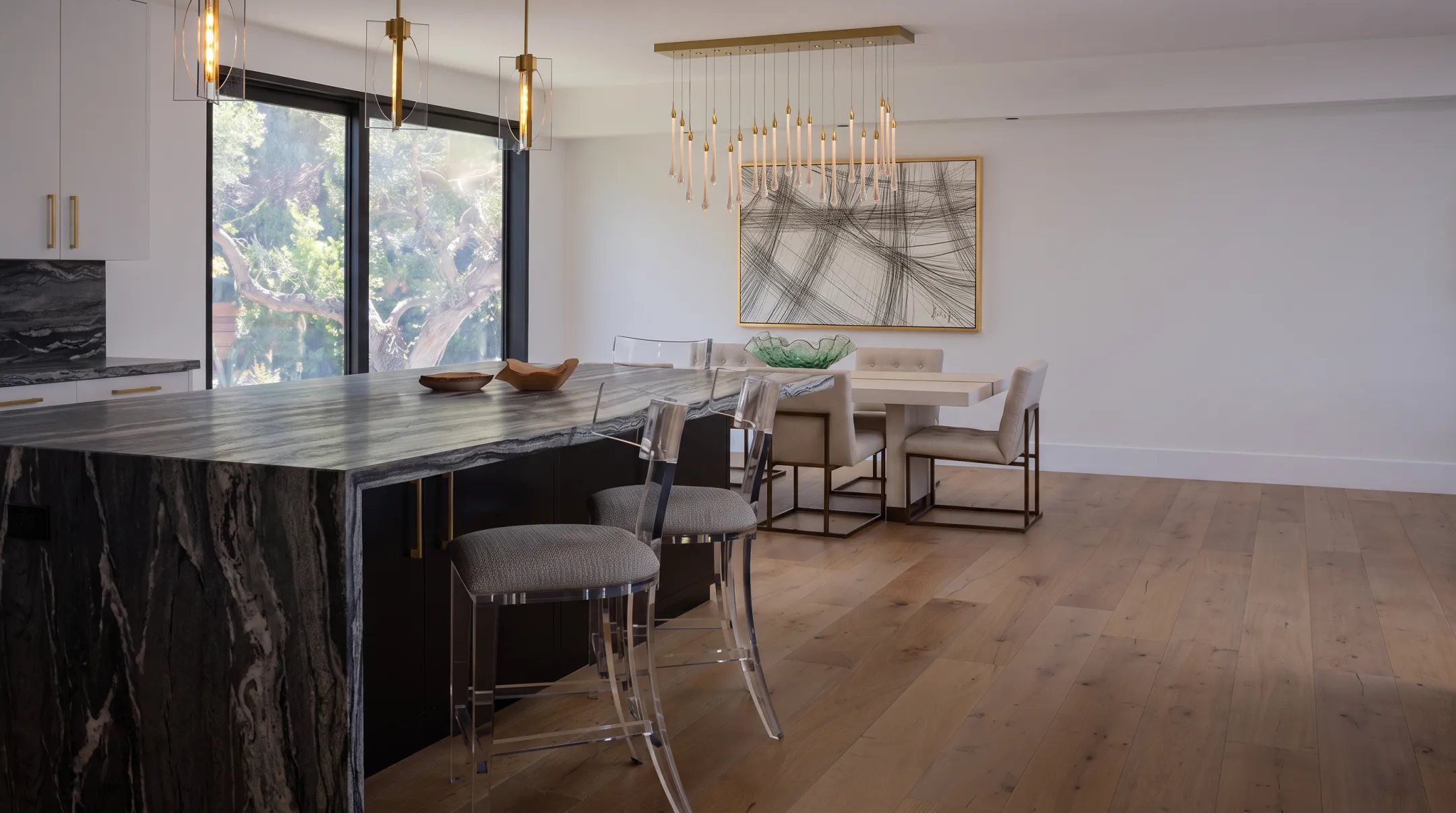 Modern kitchen island with dark cabinetry and glowing pendant lights
