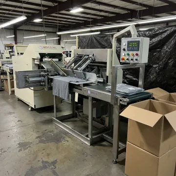 Industrial t-shirt folding and packaging machine in operation