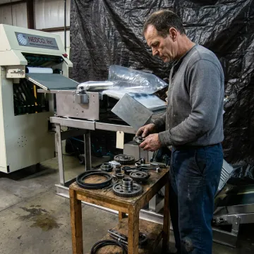 Technician inspecting industrial machine parts