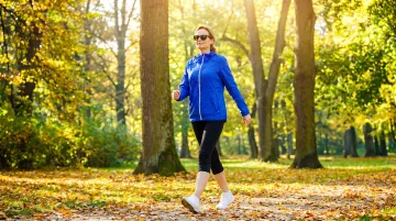 Person taking a brisk outdoor walk during midday work break for focus