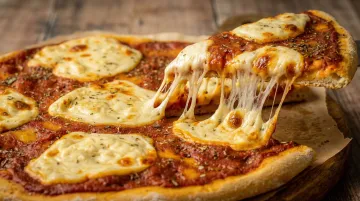 Vegan pizza with melted mozzarella showing golden brown bubbles and stretch