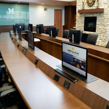 NOVA Solutions conference table with integrated monitor lifts in a professional boardroom