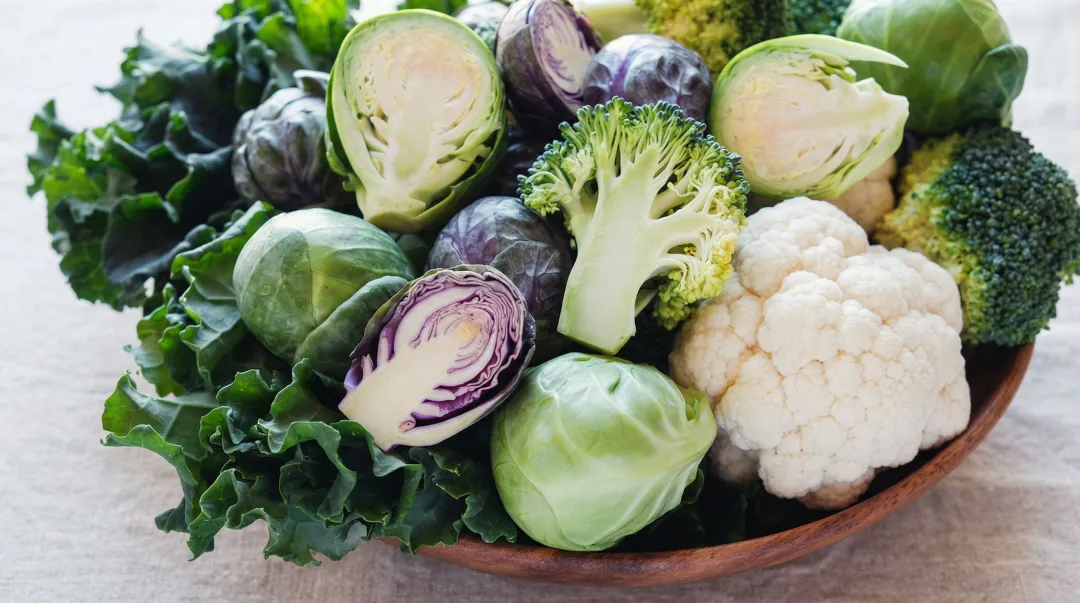 Variety of fresh cruciferous vegetables including broccoli kale and Brussels sprouts